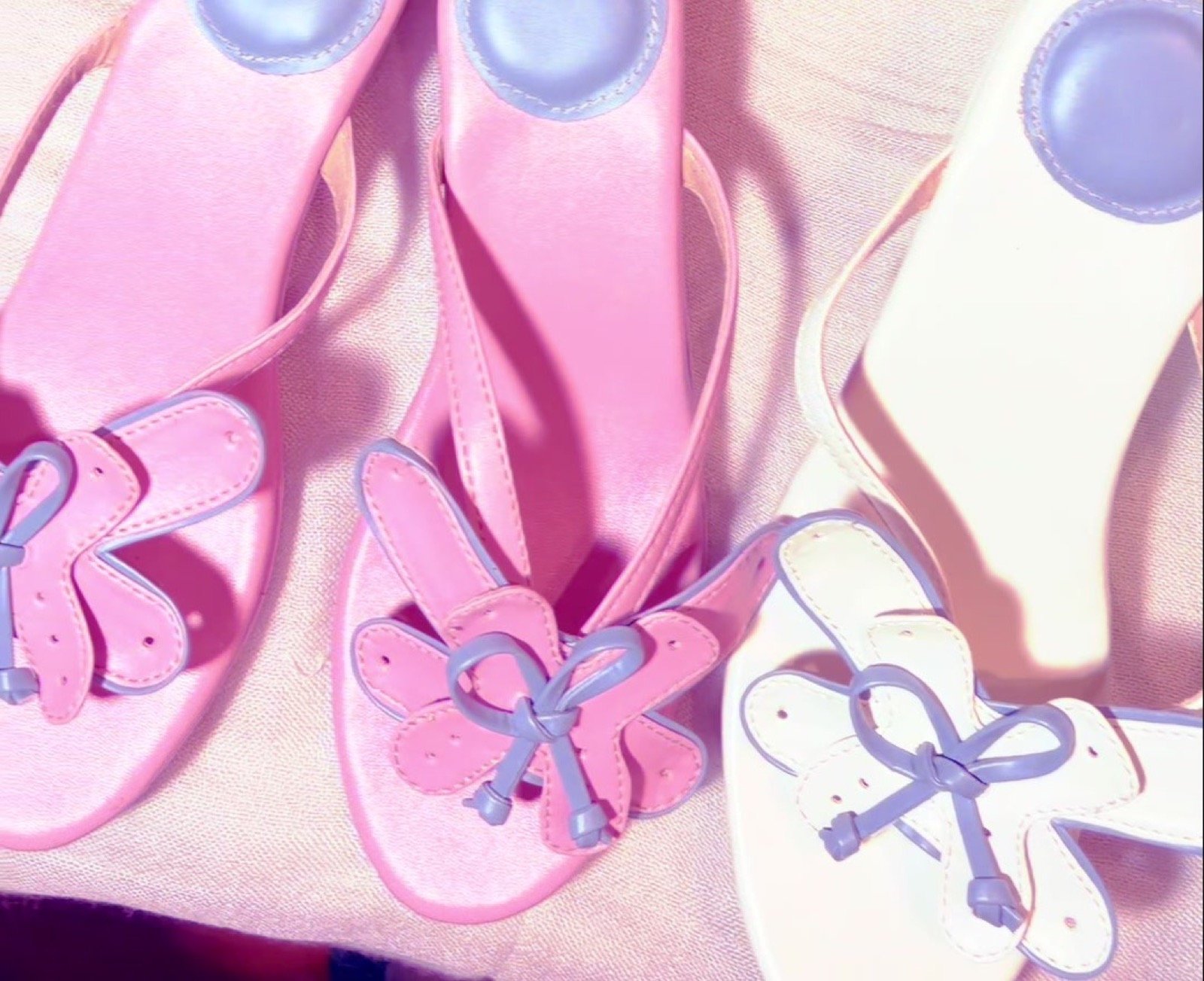 The butterfly bow sandal shown in baby pink and white colorways
